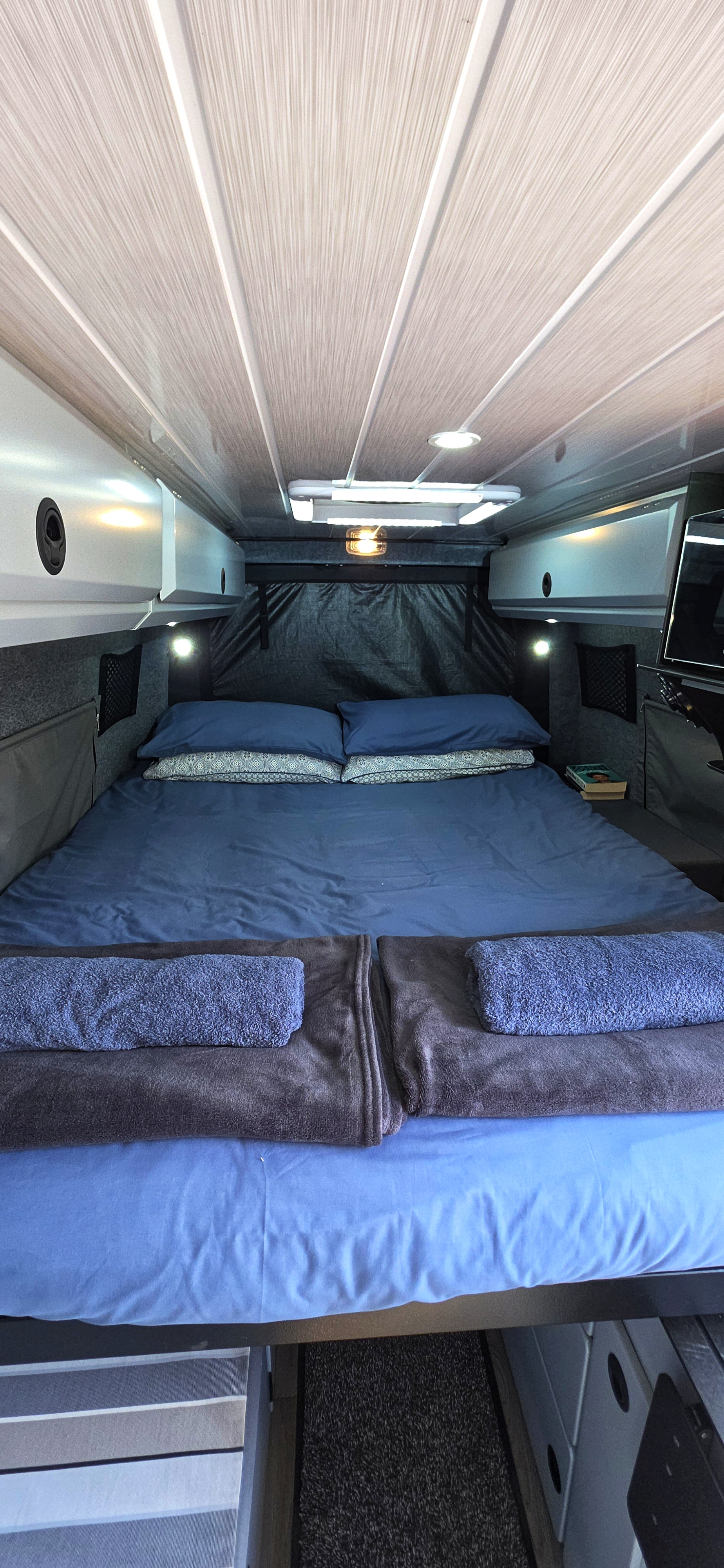 Comfortable double bed with premium linen inside the Road Safari van.